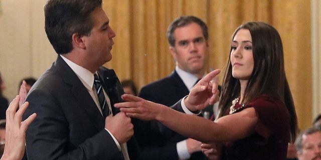 Acosta continues to speak to the President after a White House aide was directed to take the microphone.